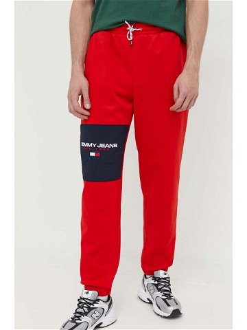 Tepláky Tommy Jeans červená barva s aplikací