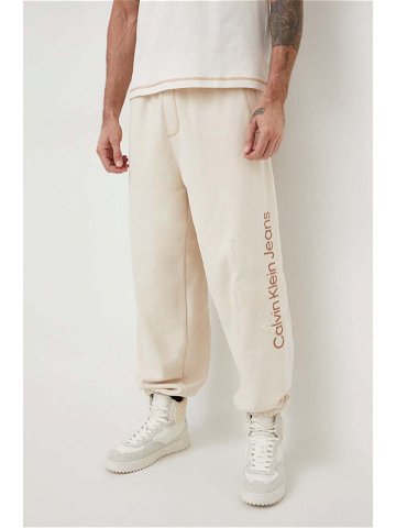 Bavlněné tepláky Calvin Klein Jeans béžová barva s aplikací J30J324953